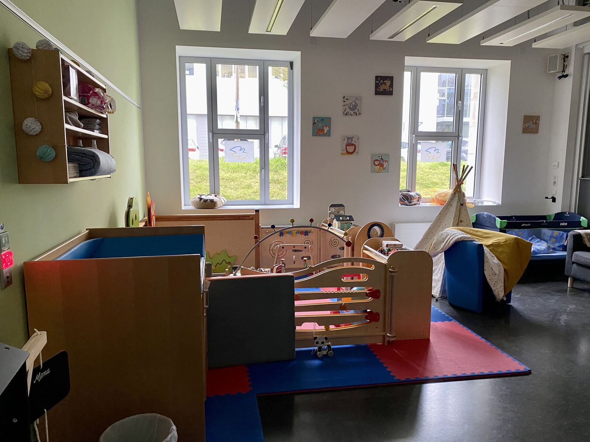 Eltern-Kind-Raum mit Spieleecke und Kinderbett