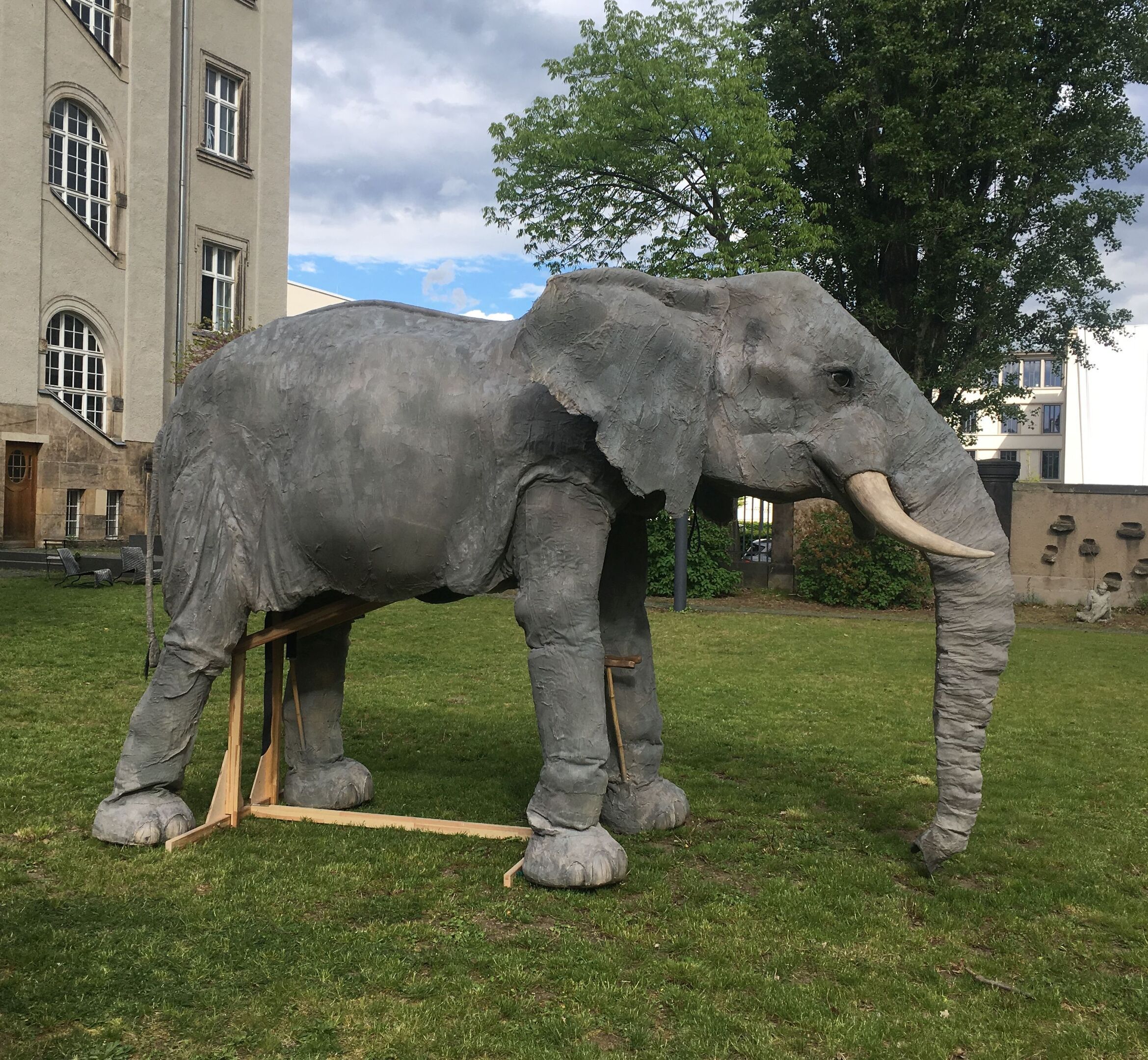 Theaterplastik eines lebensgroßen Elefanten auf einer Wiese