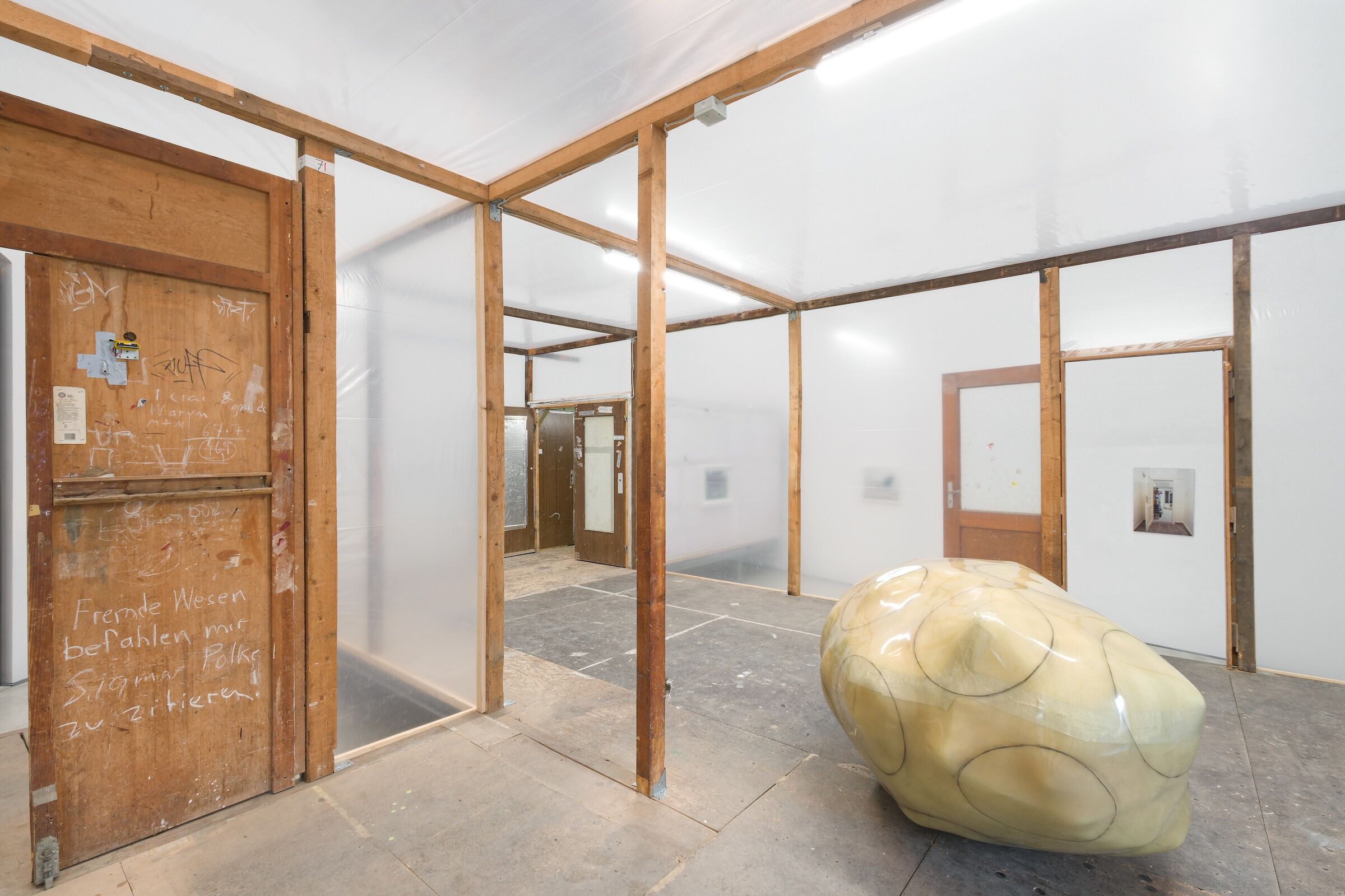 Ein Raum im Raum, gespannt aus Balken und Folie mit einer künstlerischen Arbeit drin.