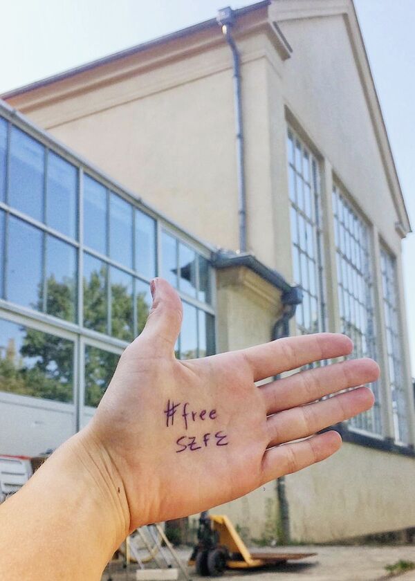 #FreeSZFE Hand mit Hashtag FreeSZFR vor dem Ateliergebäude Pfotenhauerstraße