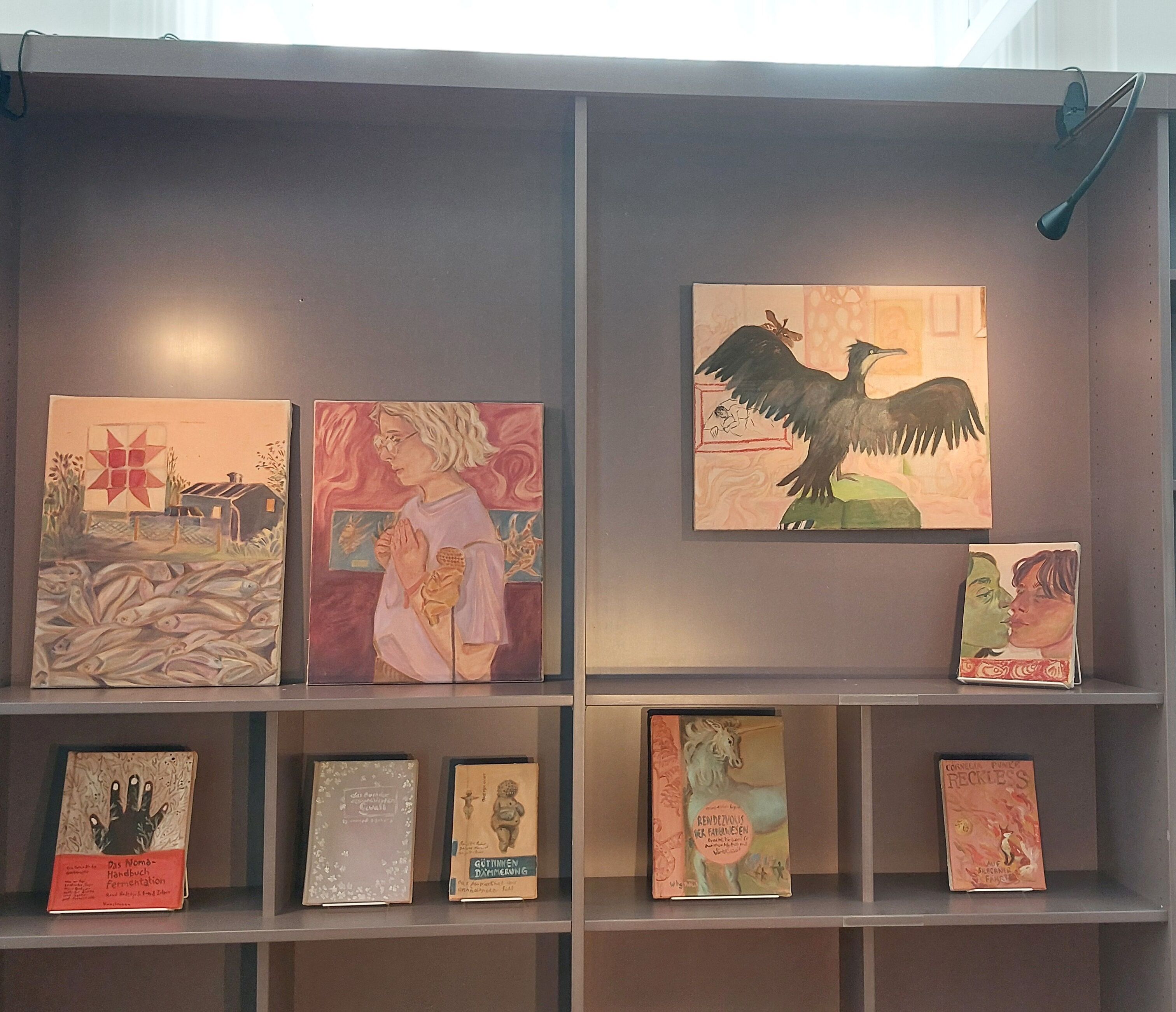 Shelf with books and small scale paintings