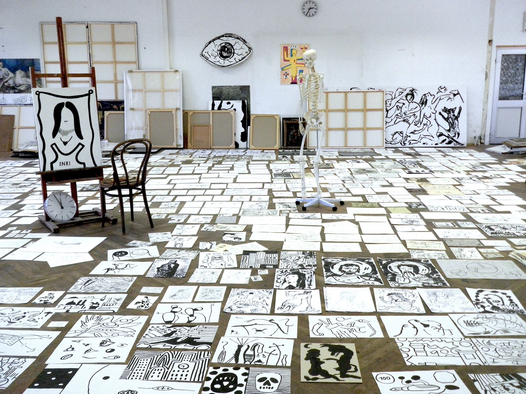 Atelieransicht mit Papieren auf dem Fußboden ausgebreitet.