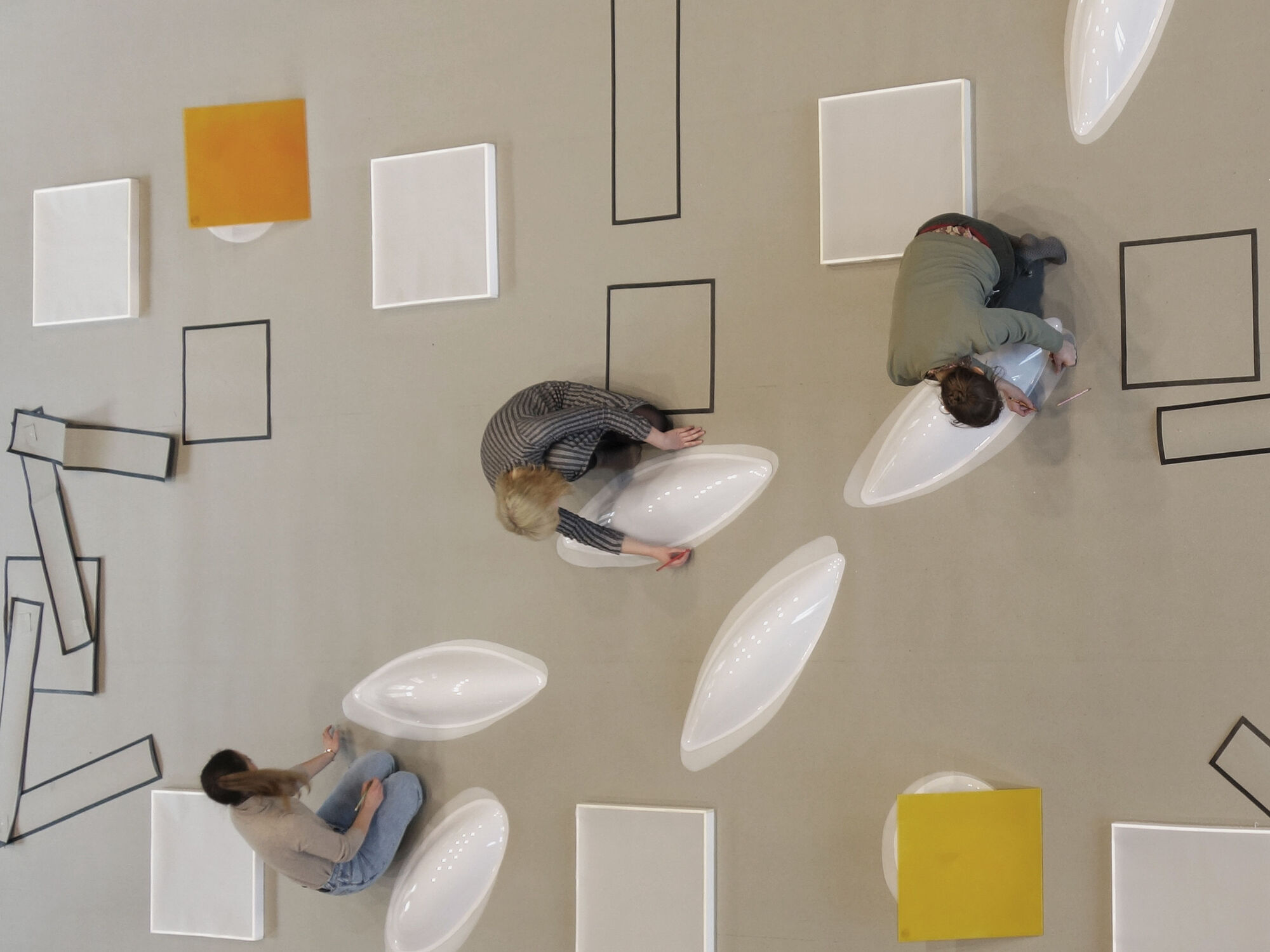Drei Studentinnen zeichnen die Konturen von verschiedenen Objekten auf dem Boden.
