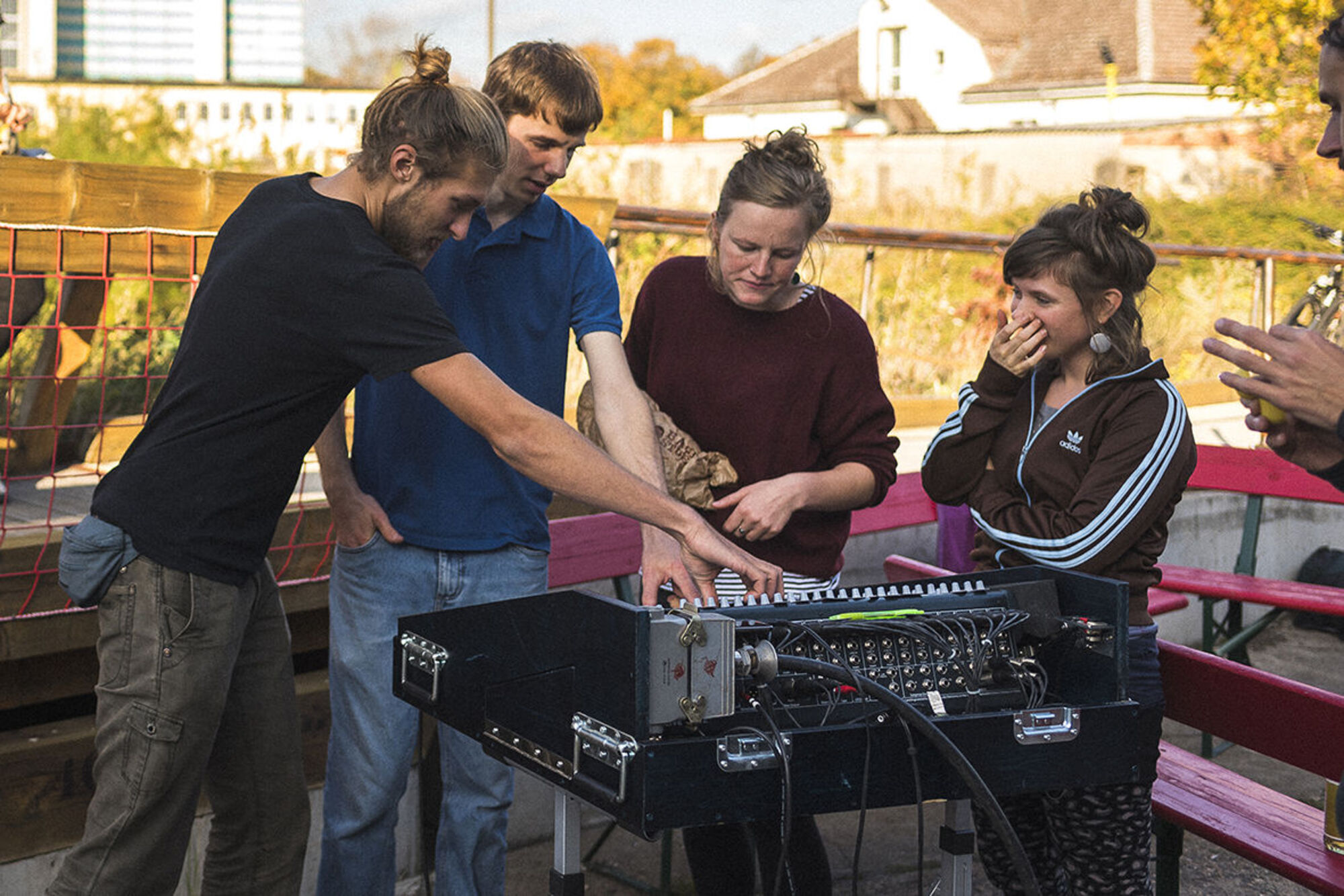 Fünf Menschen stehen neben einem Musik-Mixer.
