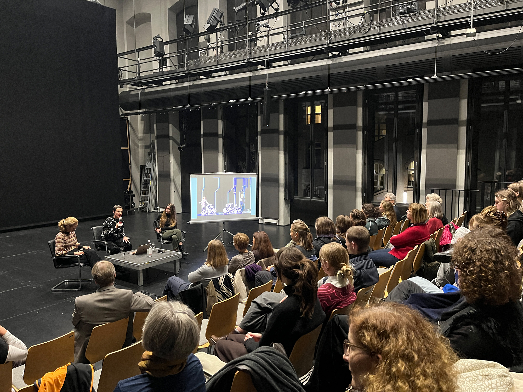 Eine Podiumsdiskussion auf einer kleinen Theaterbühne