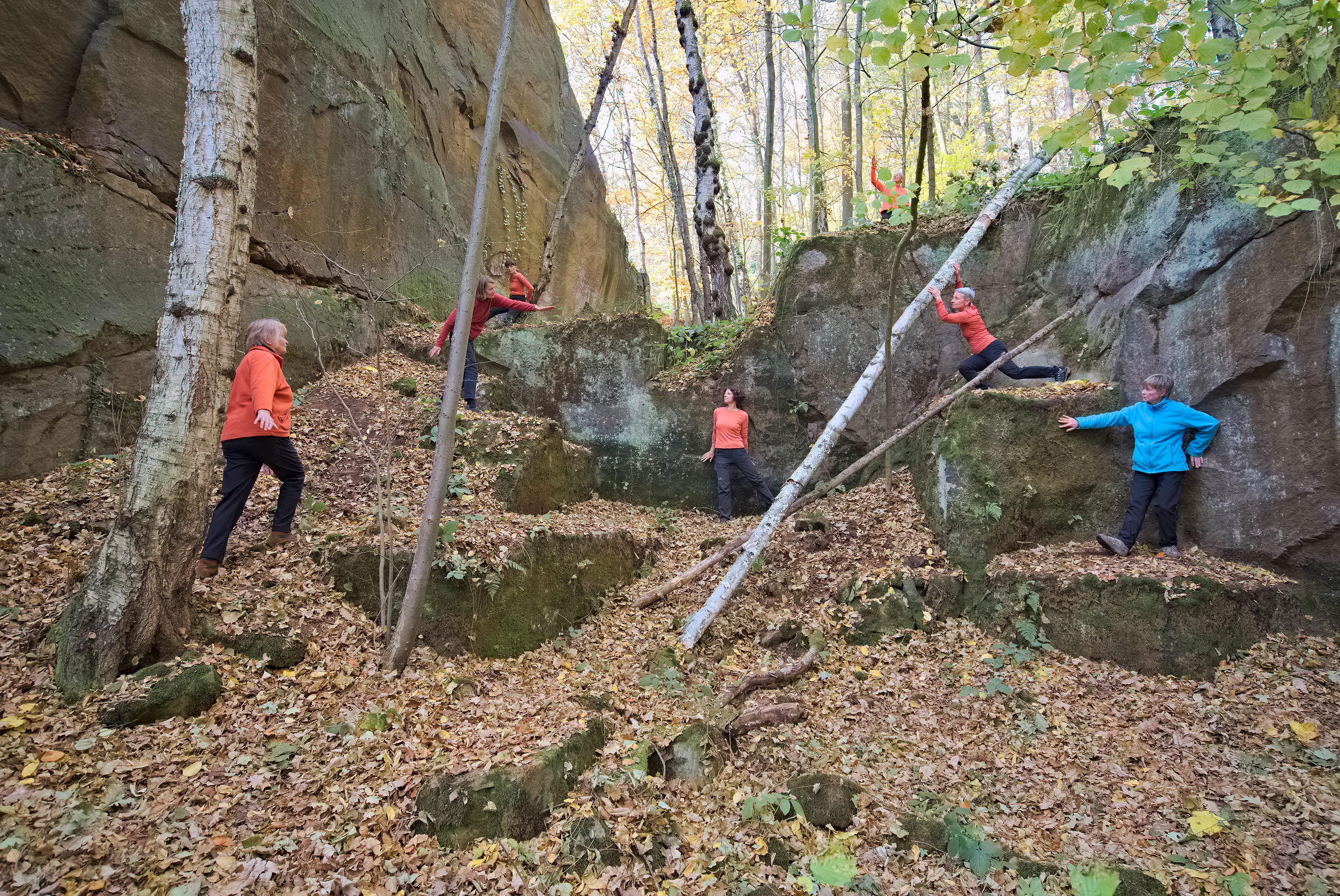 Menschen im Wald zwischen Bäumen und Felsen