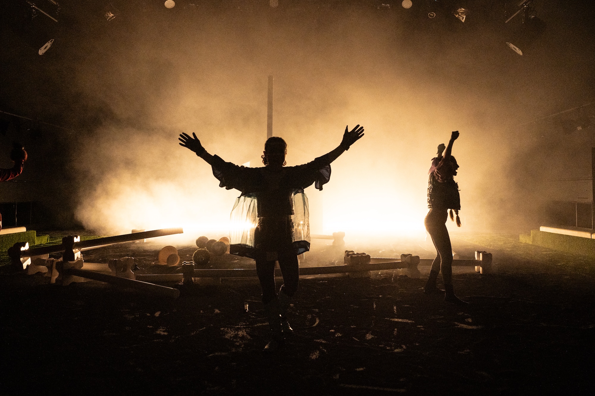 Personen tanzen auf einer Bühne, Aufnahme gegen das Licht.