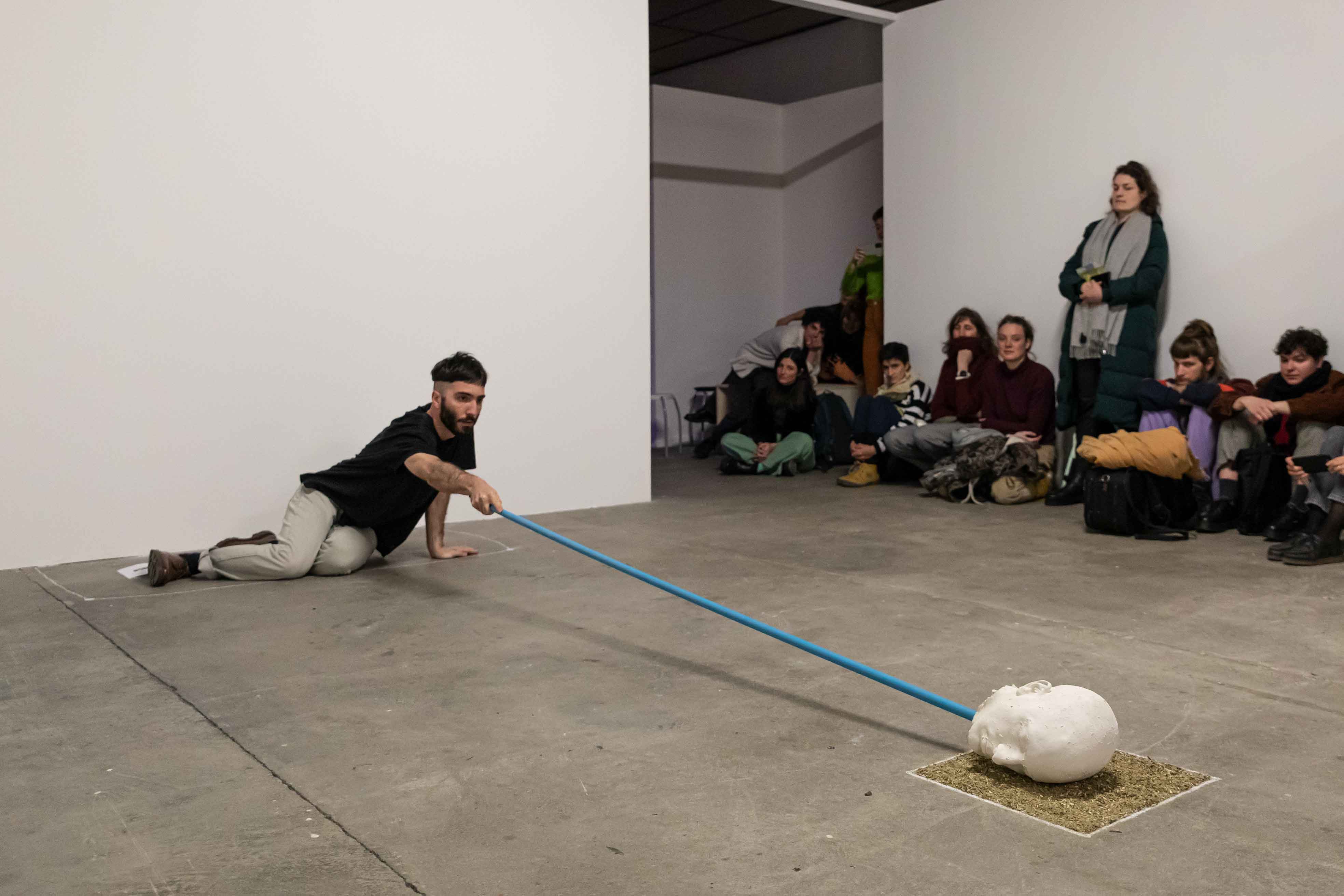 Performance, Person agiert mit Gipskopf an einem langen Stab